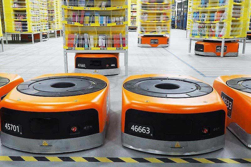 「Amazon Robotics」では自走式ロボットが棚入れや棚出しなどの作業をする