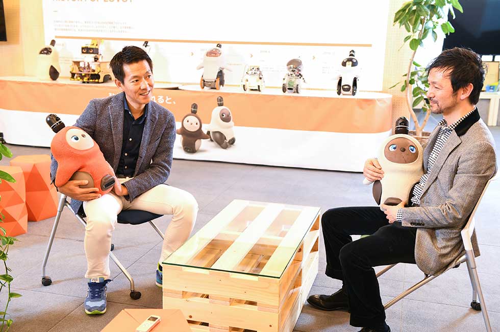GROOVE X（東京・中央）が開発・販売する家庭向けロボット「LOVOT」（らぼっと）はそのかわいらしさと、人とコミュニケーションする生き物感が人気の秘密。その生き物感はいかにしてつくられているのか。一休の榊淳社長（左）がGROOVE Xの林要社長（右）に疑問をぶつけた