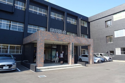 MUSUBU AIの外観。旧吉川小学校の校舎をPFI(プライベート・ファイナンス・イニシアティブ)の手法でトライアルHDが宮若市から借り受け、ほぼそのまま利用する形で再生させた。体育館は地元農家の食材を利用したレストランに生まれ変わり、校庭には次世代型スマートストア「トライアルGO脇田店inみやわかの郷」を新設した