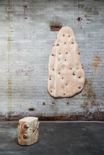 太田翔「According to the Grain: Coat rack(アコーディング・トゥ・ザ・グレイン: コートラック)」。平らな木材の表面から12ミリメートル削り、節を浮き出すように彫り出して制作。板材になって人間が扱いやすいようになったものに対し、もう一度その中に眠っている野生の部分を掘り起こすような作品。触れることでも素材を感じ、体験し、鑑賞できる(撮影/Yuta Sawamura、画像提供/21_21 DESIGN SIGHT)