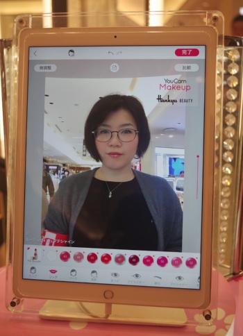 YouCam メイクの画面。カメラで顔を写し、画面下のアイコンで試したい商品や色を選択すると、顔の画像にメークがリアルタイムで合成される