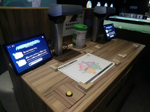 デジタル紙相撲「PAPER RIKISHI」。枠内に塗り絵を置き、ボタンを押すと読み込みが始まるため、小さい子でも簡単に遊べる