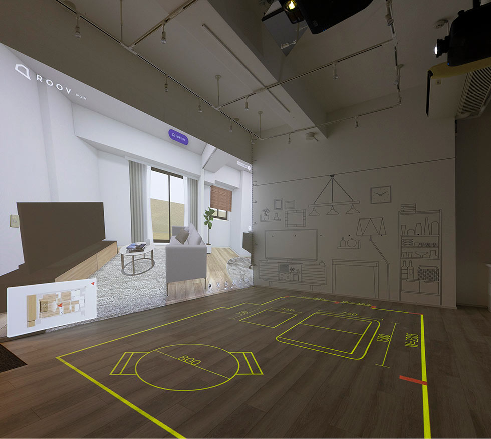 体感型VRモデルルームでは、希望する部屋のイメージをスタイルポートのVR内覧ツール「ROOV walk（ルーブ ウォーク）」による大画面VRで壁に投影できる。それに他社のプロジェクションマッピングを組み合わせた