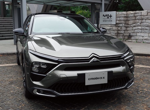 「C5 X」を前方から見たところ。高級セダンに見えるが、後方から見ると違う車種にも見える。灰色の路面と車のニュアンスカラーのグレーの相性は良さそうだ