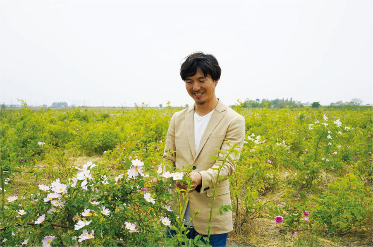 「野ばら」の農園で説明をする國枝健一氏。食用バラは屋外エリアで栽培している