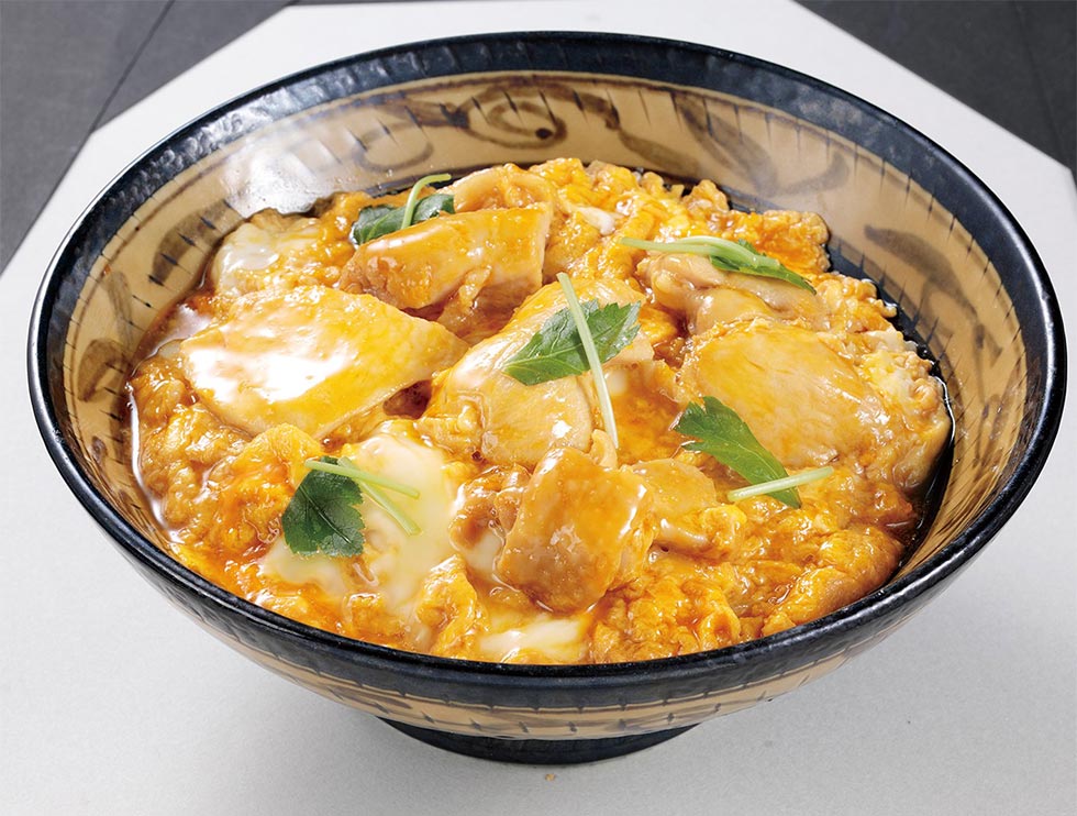 親子丼は漬物とシジミのみそ汁が付いて850円（税込み）。肉を増量して卵黄を乗せた「上」もある（税込み1000円）