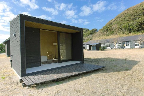 無印良品の小屋がある「シラハマ校舎」。右奥が校舎。小屋の代金以外に施設整備費として税込み50万円、管理費税込み1万5000円 (月額)が必要。購入者は校舎部分の共有施設を使える。1棟の小屋につき家庭菜園などに利用できる約70平方メートルの土地が貸し出される