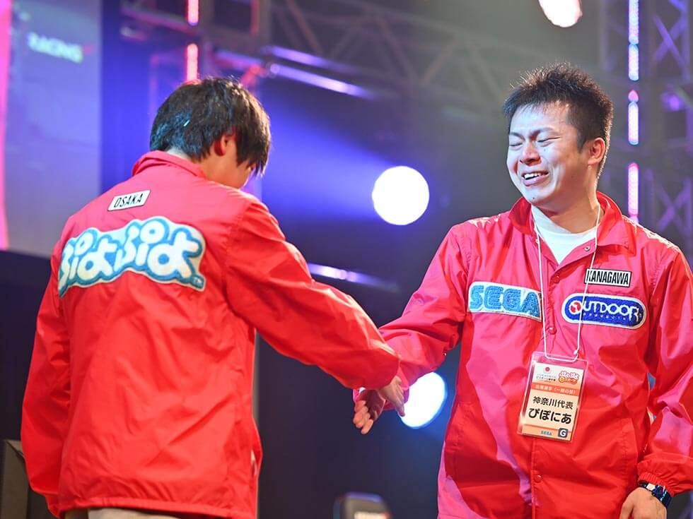 『ぷよぷよeスポーツ』一般の部の決勝はJeSU認定のプロ同士の戦いに。優勝は大阪府代表のマッキー選手（左）。負けた神奈川県代表のぴぽにあ選手（右）は、悔し涙を流しながらも笑顔で握手を交わした（写真／酒井康治）