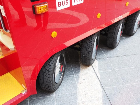 片側5輪の計10輪。すべてがインホイールモーターを組み込んだ駆動輪である。前側8輪はハンドルを切ると操舵輪として角度が変わる。後へいくほど切れ角が小さくなる。小型ボディーと相まって小回りが利く