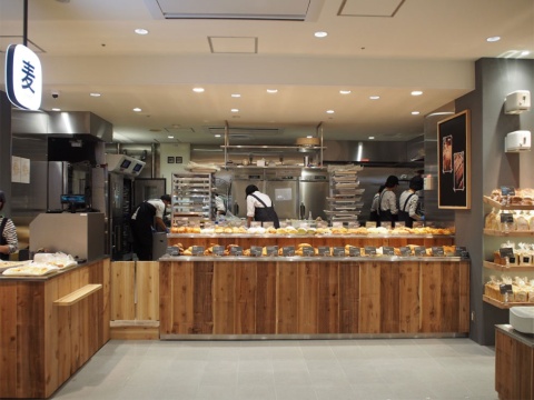 「麦」の看板の下にある店は、京都市内で3店舗展開する人気のベーカリーショップ「ブーランジェ オクダ」。オープンキッチンで職人が作る焼きたてのパンが食べられる