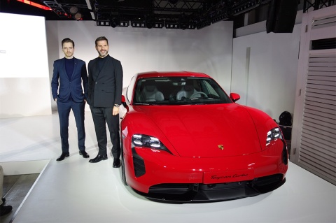 ミヒャエル・キルシュ社長(右)とプロダクトマネージャーのアレキサンダー・クワース氏。新型ポルシェ「タイカン」(欧州仕様、エクステリアカラー:カーマインレッド)のグレードは性能が高い順に「タイカンターボ S」「同ターボ」(写真)、「同4S」の3つがある。国内での価格は未定だが、ドイツではターボSが18万5456ユーロ