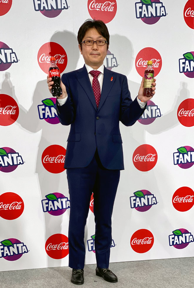 ラベルがリストバンドになることを説明する、日本コカ・コーラマーケテイング本部炭酸＆エナジーカテゴリーバイスプレジデントの島岡芳和氏