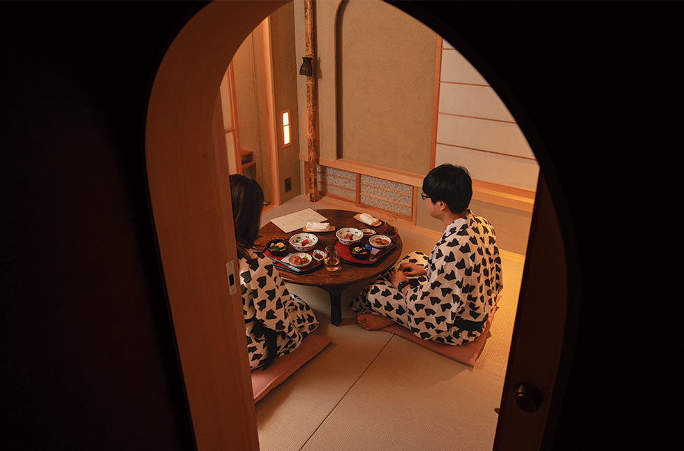 客室で夕食をとる宿泊客。アールの入り口は、くぐるようにして入る茶室の「にじり口」がモチーフ