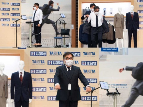 4月26日に行われた発表会では、はるやま商事の中村社長とタニタの谷田社長が体組成計の計測とジャケットのフィッティングを実演。写真は中村社長