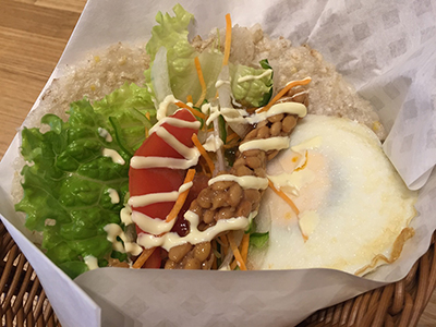 おこげシートと相性抜群の納豆をサンドした「納豆タマゴ」（税込み500円、279kcal）。「日本人になじみのある味に仕上げ、満足感を追求した」とのことで、想像以上の相性の良さに驚いた