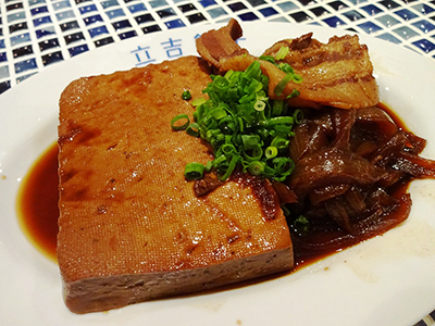常連が必ず頼むという人気メニュー「豪快！肉豆腐」（590円）はタレを真っ黒になるまで染み込ませた豆腐。トロトロになるまで煮込んだタマネギ、豚肉、ネギを添えている