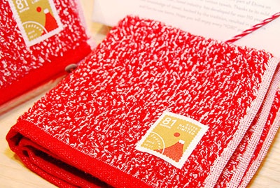 2階のショップ群のひとつ、「伊織」はタオルソムリエが1人ひとりに合ったタオルをセレクト。写真はKITTE名古屋限定の「letters」（1080円）。郵便マークの赤と切手をモチーフとし、岐阜の美濃和紙を織り込んである