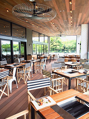南堀江の人気カフェ「グッドスプーン」の2店舗目。全136席のうち、BBQができるテラス席は70席。周囲の自然となじむように、天井から床まで全面木で統一されたおしゃれな内装が印象的
