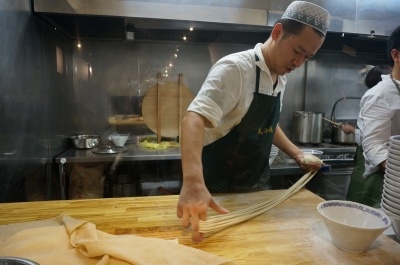 麺を手打ちするマーズルーの清野烈店長。団子状の生地が、1～2分で麺になっていく様子を、オープンキッチンで見ることができる