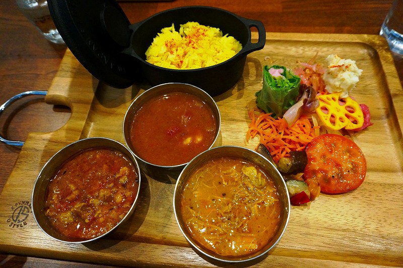 副菜＋カレー3種の「カレープレート」（税込み1300円）。ポークキーマ（左）、えび（中央）、チキン（右）。はやりのサラサラ系のカレーで、特にエビはビスクスープのような濃厚な味わい。ビーツ入りのポテトサラダ入り生春巻きやサラダなどの副菜もおいしかった