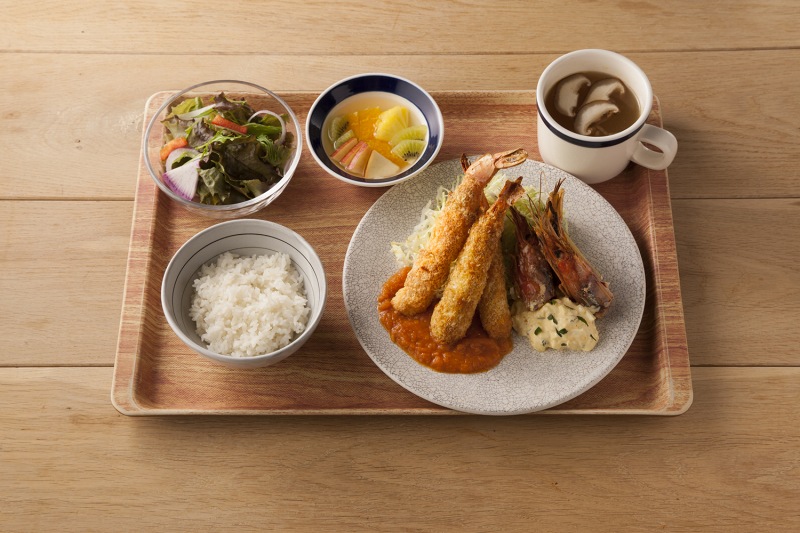 「エビフライ 自家製タルタルと野菜ソース」（1250円）。エビフライは揚げずに焼いており、タルタルソースにいぶりがっこを加えている。553kcal、塩分2.8ｇ