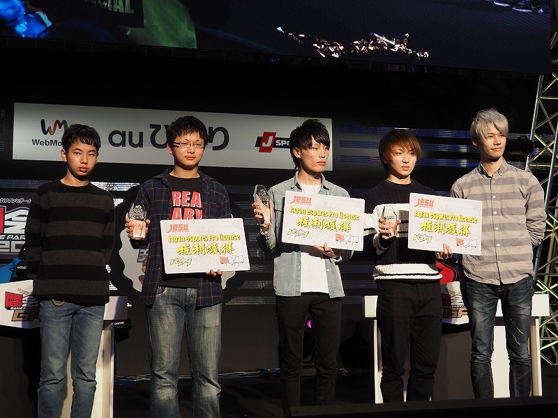 大会最後のフォトセッションには上位入賞の3人とともに、例外的ライセンス発行によって『パズル＆ドラゴンズ』のプロライセンスを獲得している「LUKA」選手（右）と、同じくジュニア・プロライセンスを持つ「ゆわ」選手（左）も登壇
