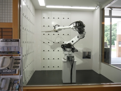 クロークサービスでは、ロボットアームが荷物を出し入れする