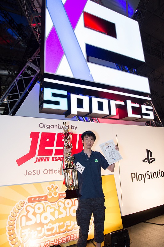 巨大なトロフィーと賞状を手にする優勝したざいろ選手。賞金100万円のほか、副賞として「PS4 Pro」も獲得した。