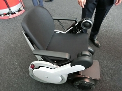 WHILLの「WHILL NEXT」は、人が座って乗る車椅子型のパーソナルモビリティー。遠隔操作で降りた場所から自動回収もできるという