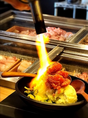 テーブルに運んでから切る、炙るなど、目の前で仕上げる料理を多くしている。「自家製ポテトサラダ」（490円）は、「焦がしチーズ」「どっさり炙り明太子」「トローリ味玉」の３種類。チーズと明太子は、目の前でバーナーで炙り、味玉は目の前でカットして、ライブ感を演出している