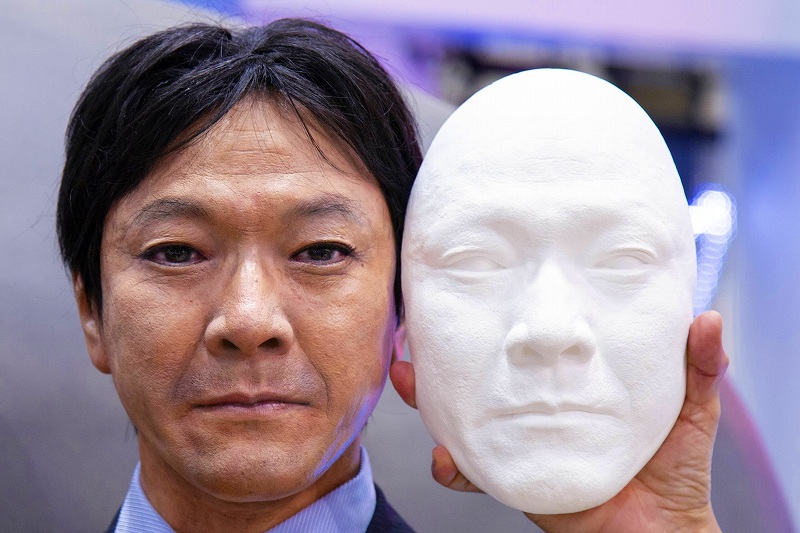 山田相談役の顔を型取りした石こうの面（右）。耐久性と軽量化を図るため、この面の材質を樹脂に替えてマネキンに組み込み、輪郭や頭部の形状を合わせて彩色、ウイッグをかぶせたパーフェクションスーパーリアルマネキン（左）