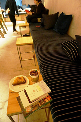 ゆったり座ってリラックスしながら本が読めるように置かれた、奥行きのあるソファ。飲食はソファのあるラウンジ限定でOK。同ビル内の飲食店で購入したピザも持ち込める